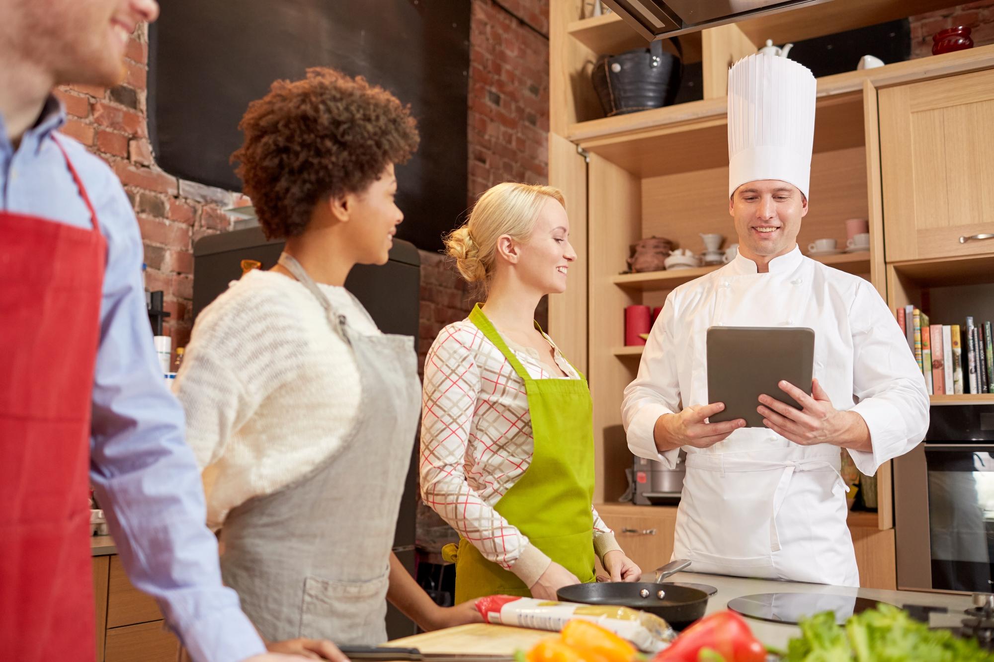 Small modern teaching kitchen with chef and students
