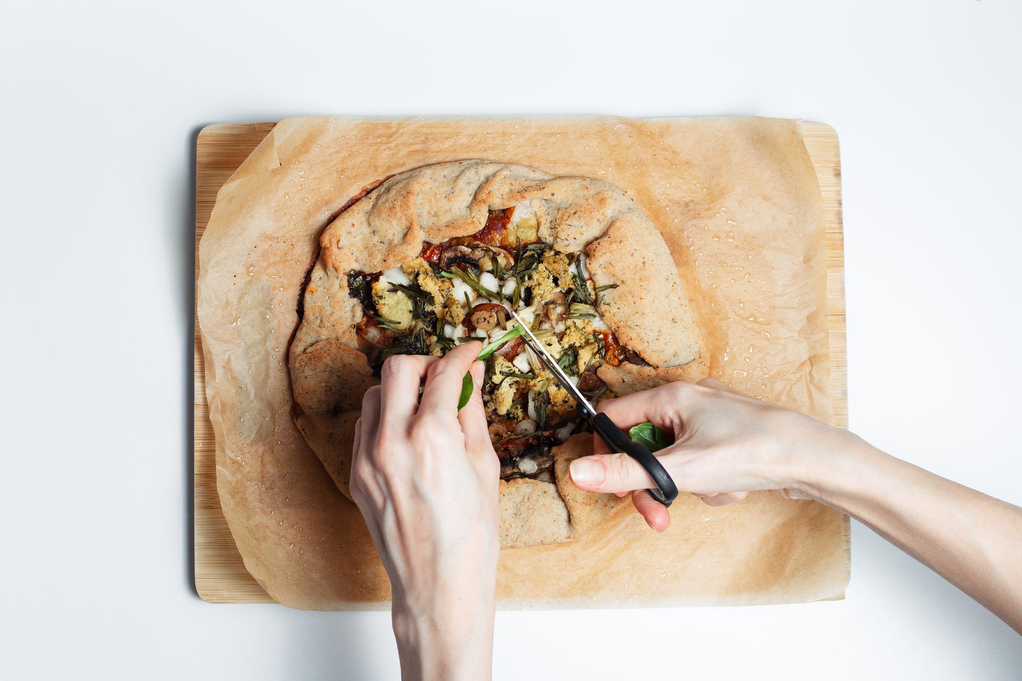 Student plating a dish on a wooden board