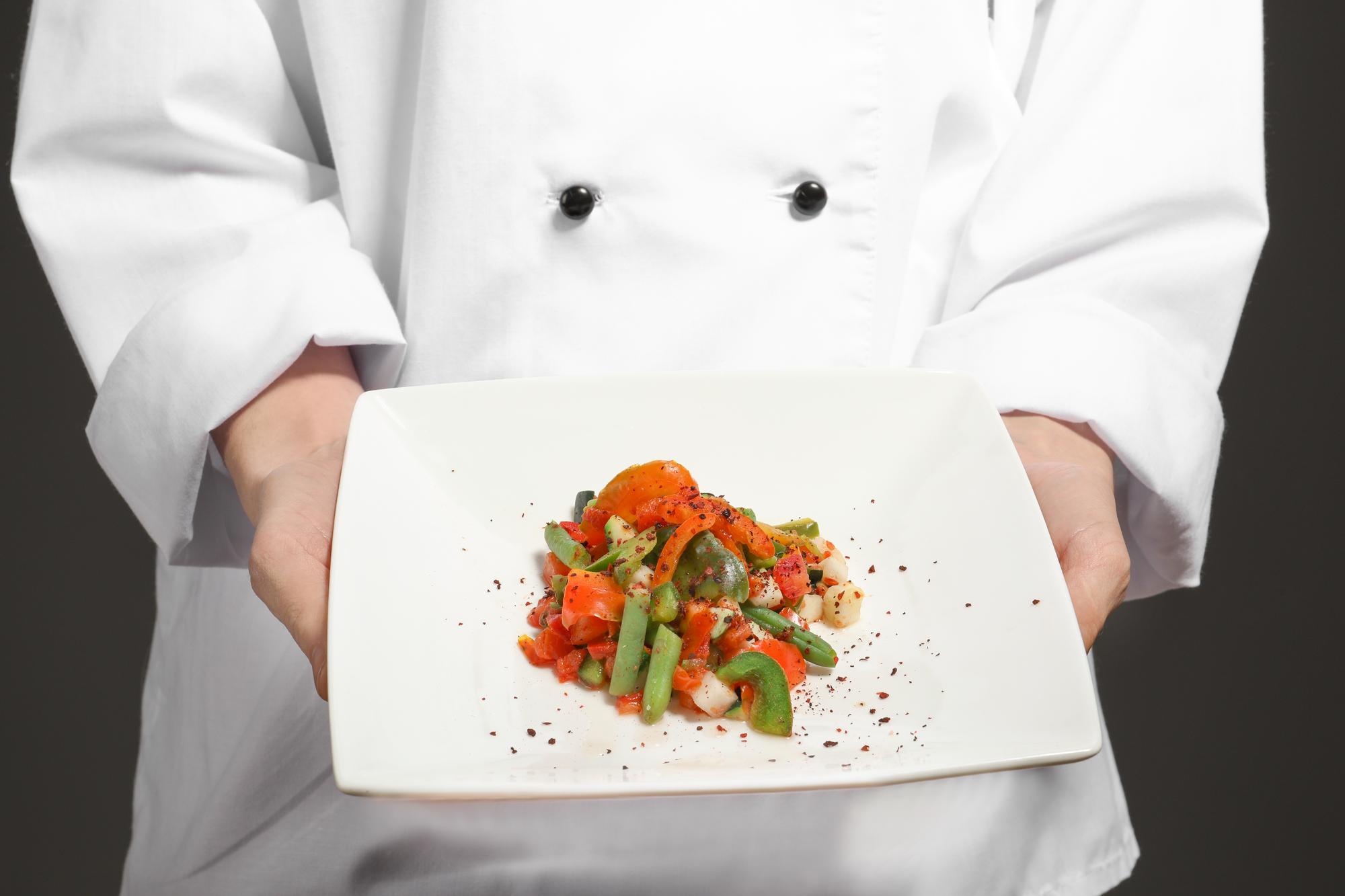 Chef preparing modern plated dish in tech-forward kitchen